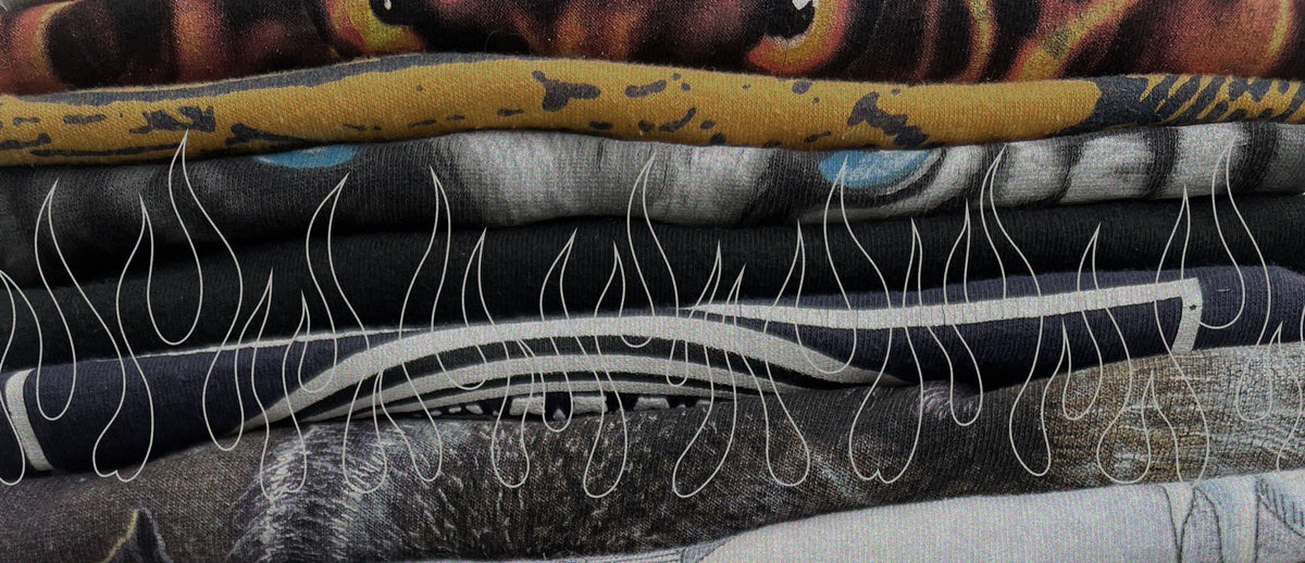 Stack of faded vintage graphic T-shirts with flame artwork.